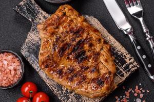 Juicy pork steak baked on the grill with salt, spices and herbs photo