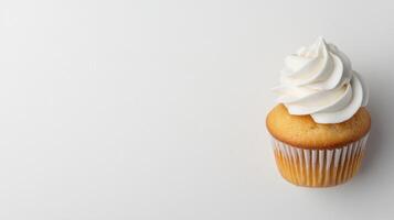 Delicious vanilla cupcake with creamy frosting on a plain background photo