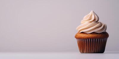 Freshly baked cupcake with creamy frosting on a plain background photo