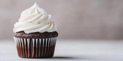 Delicious chocolate cupcake with white frosting on a simple backdrop photo