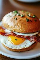 Delicious breakfast sandwich with bacon and egg on a soft bun photo