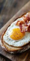 Perfectly cooked egg on toast with crispy bacon for breakfast photo