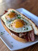 Breakfast sandwich with bacon and sunny side up eggs served fresh photo