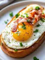 Delicious breakfast toast topped with fried egg and crispy bacon photo