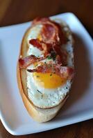 Delicious open-faced sandwich with fried egg and crispy bacon photo
