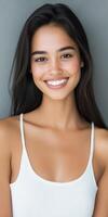 Young woman with long hair smiling on a gray background photo