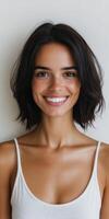 Smiling woman with short dark hair on neutral backdrop photo