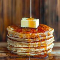 Stack of fluffy pancakes drizzled with syrup and butter photo