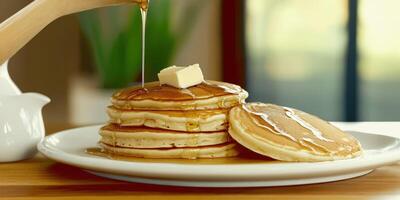Delicious stacked pancakes with syrup and butter on a plate photo
