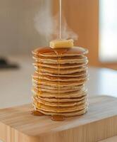 Delicious stack of pancakes with melting butter and syrup photo