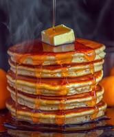 Stack of warm pancakes with syrup and butter on top photo