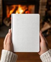 Cozy evening by the fire with a blank notebook in hand photo