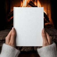 Cozy evening by the fire with a blank book in hand photo