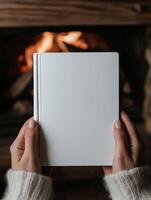 Cozy moment by the fire with a blank journal in hand photo