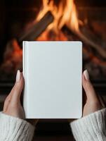 Cozy evening by the fire with a blank book in hand photo