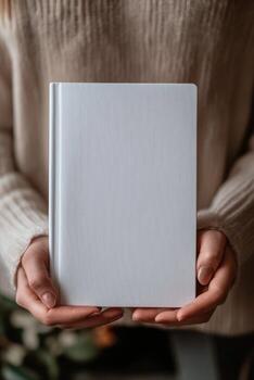 Holding a blank notebook with textured cover indoors photo