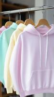 Stylish pastel hoodies hanging on display rack in boutique photo