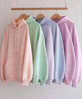 Cozy hoodies in soft pastel colors hanging on display photo