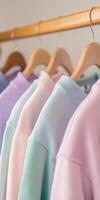 Colorful sweaters hanging neatly on wooden hangers photo