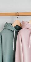 Cozy hoodies displayed on wooden hanger in soft colors photo