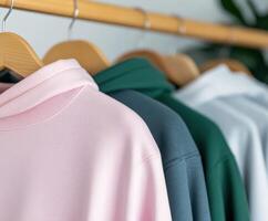 Casual hoodies displayed on a wooden hanger rack photo