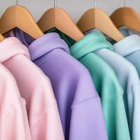 Colorful hoodies displayed on wooden hangers in a shop photo