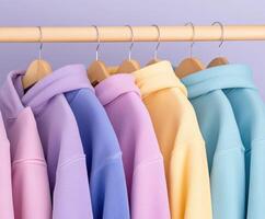 Colorful hoodies hanging on a wooden rack in a stylish display photo