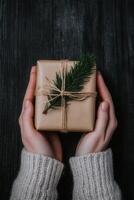 Present wrapped in brown paper held by hands with sweater photo