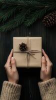 Wrapping a gift with pinecone decoration during winter season photo