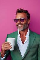 Man in sunglasses holding a coffee cup by a vibrant pink wall photo