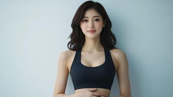 Fitness model poses in athletic wear against a light background photo