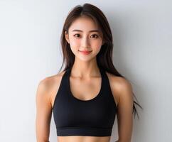 Young woman poses confidently in athletic wear against a wall photo