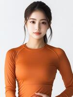 Model poses in fitted orange athletic top for fitness shoot photo