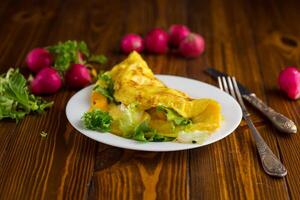 egg roll with sweet pepper and salad, on a wooden table photo