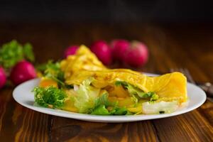 egg roll with sweet pepper and salad, on a wooden table . photo