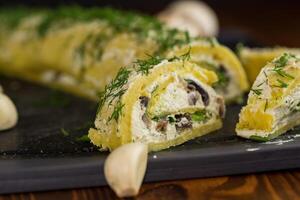 baked potato roll with cottage cheese filling with garlic and mushrooms, on a dark wooden table photo