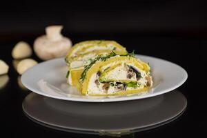 baked potato roll with cottage cheese filling with garlic and mushrooms, isolated on black background photo
