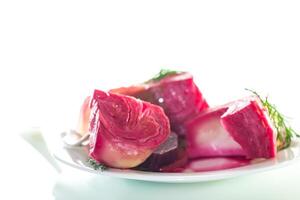 pickled cabbage with beets and carrots, in a plate, isolated on white background photo
