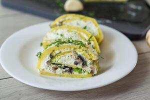 baked potato roll with cottage cheese filling with garlic and mushrooms, on a light wooden table photo