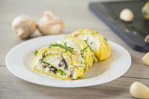 baked potato roll with cottage cheese filling with garlic and mushrooms, on a light wooden table photo