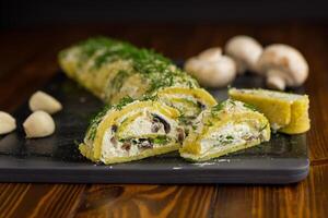 baked potato roll with cottage cheese filling with garlic and mushrooms, on a dark wooden table photo
