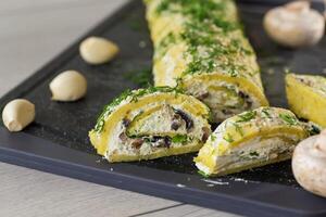baked potato roll with cottage cheese filling with garlic and mushrooms, on a light wooden table photo