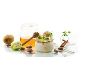 Homemade yogurt in a glass jar with honey, kiwi, nuts. photo