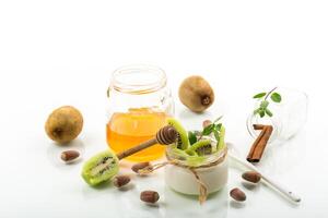 Homemade yogurt in a glass jar with honey, kiwi, nuts. photo