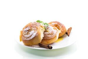 Baked goods. Sweet buns with cottage cheese filling and honey in a plate isolated on a white background photo