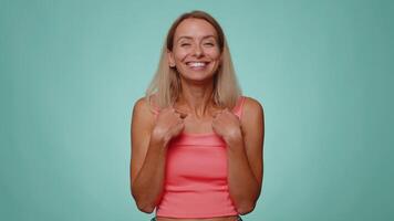 Woman pointing to camera and looking with playful happy expression, making choice, showing direction video