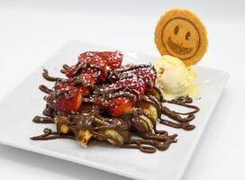 Waffles with chocolate and strawberries on a white plate close-up photo