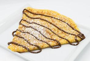 Pancakes with chocolate on a white background, close-up photo