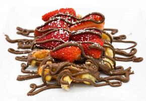 Waffles with chocolate and strawberries on a white plate close-up photo