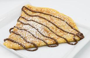 Pancakes with chocolate on a white background, close-up photo